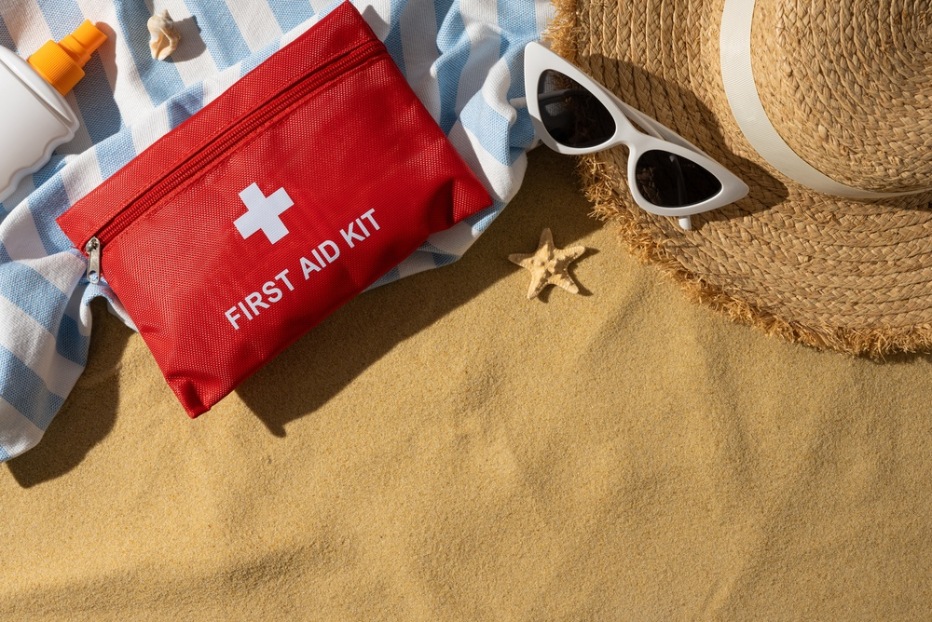 A compact travel first-aid kit and sunscreen packed for a family trip in Phuket.