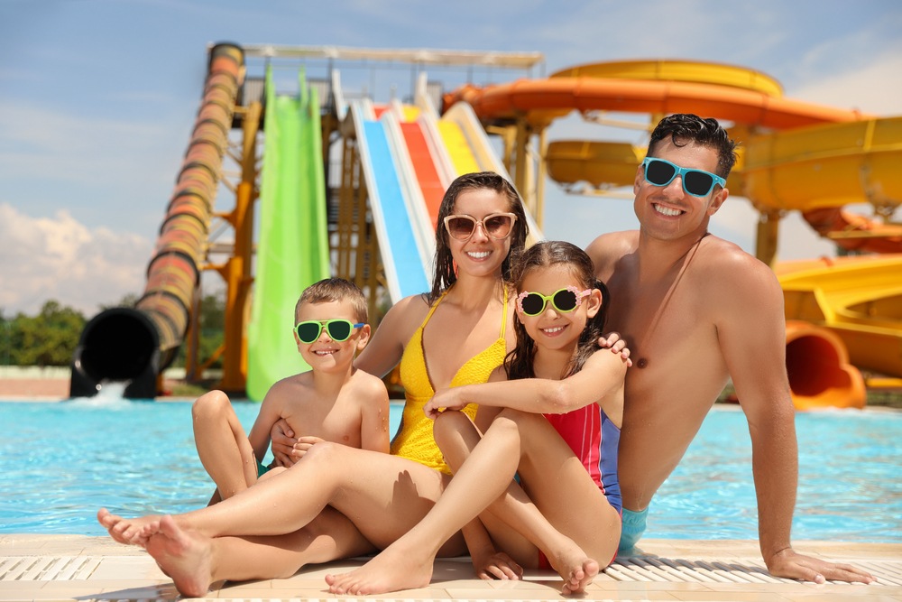 A family in swimwear and goggles at a water park. A Phuket family packing list should cover essentials.