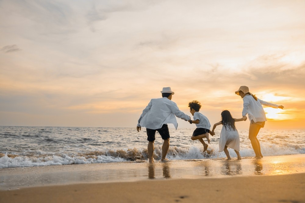 A happy family enjoying the beach in Phuket - one of the top kids friendly destinations