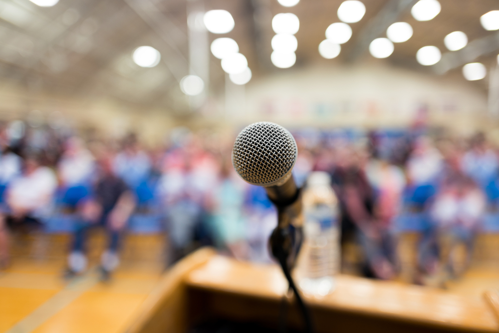 A microphone on a podium in front of an audience