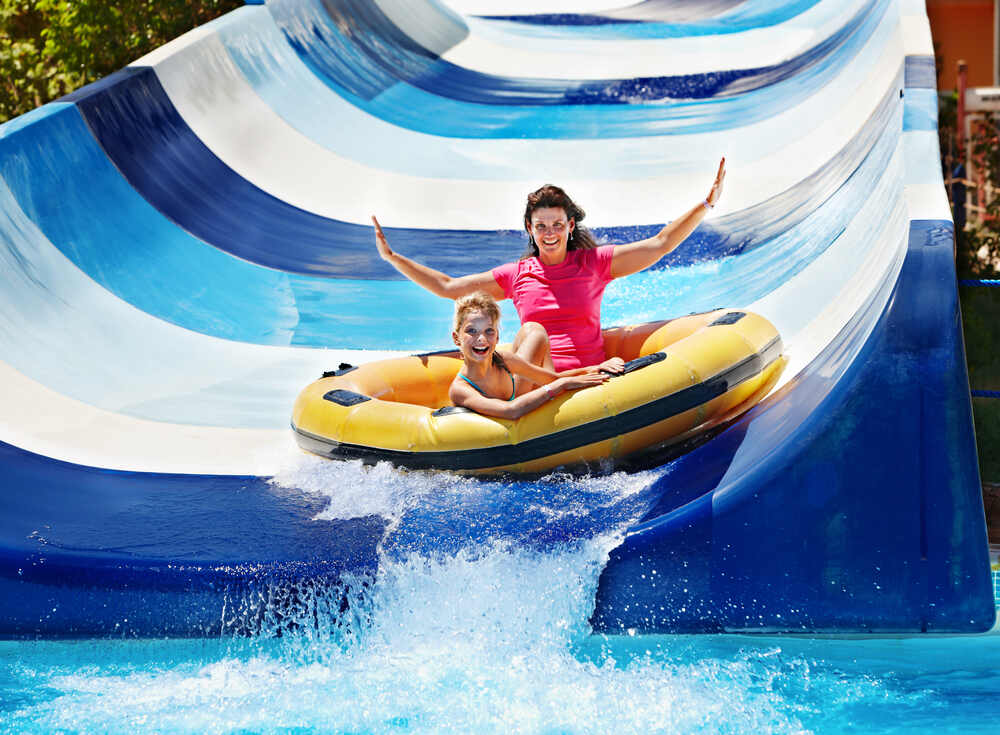 A mother and son having fun on a water slide 