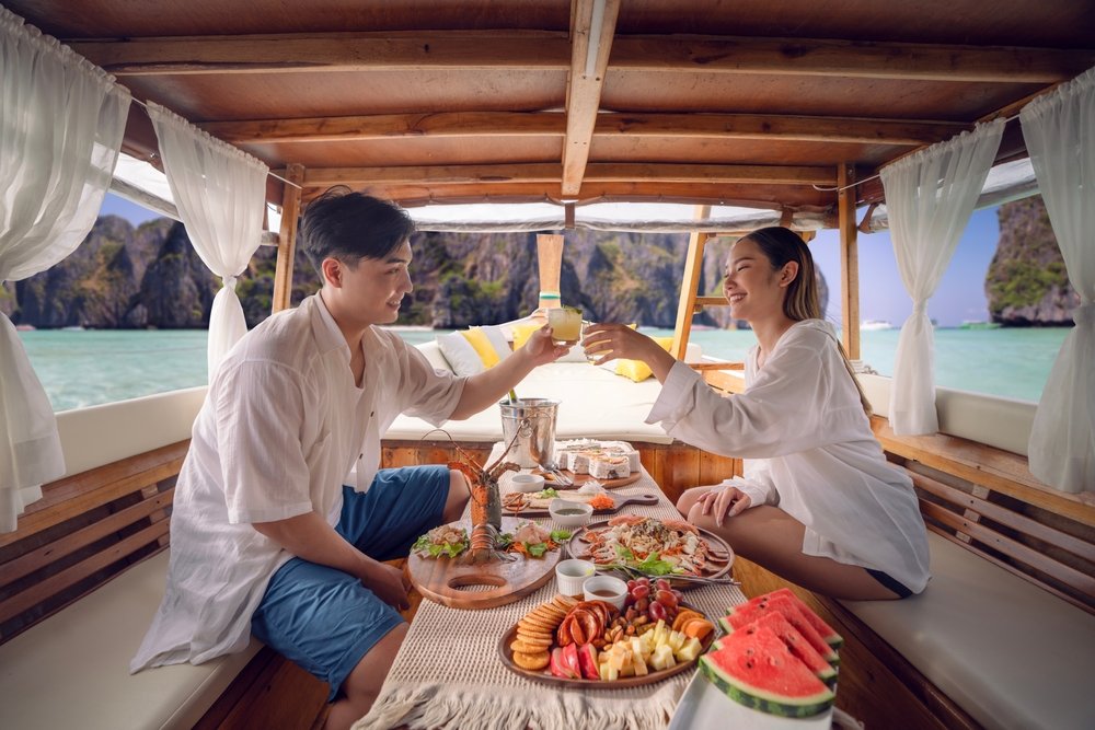 A young Asian couple shares a meal on a private sunset cruise in Phuket