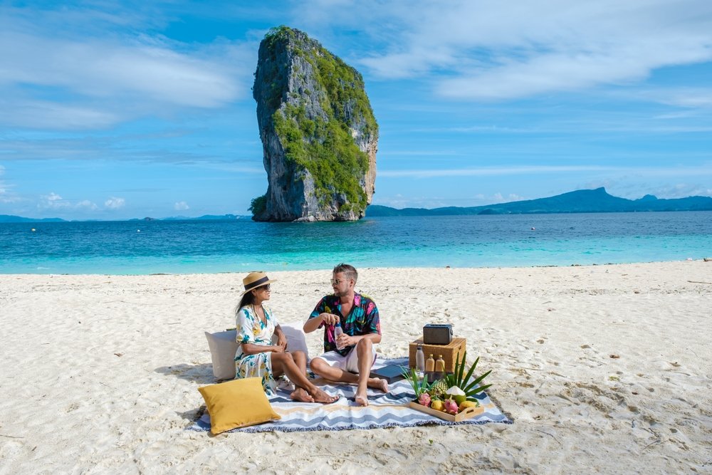 A young couple enjoys a picnic lunch on an island off Phuket
