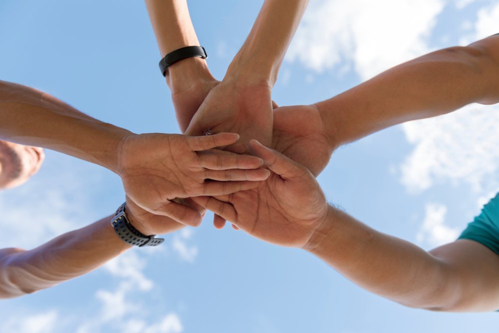 Team-building scavenger hunt participants joining hands