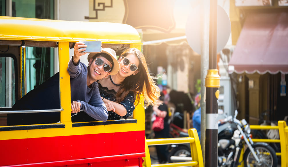 Tourists taking a photo in a tuk tuk in Phuket