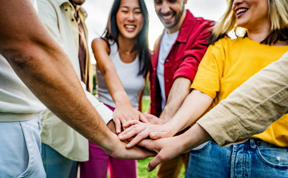 a group of people stacking hands during a corporate retreat