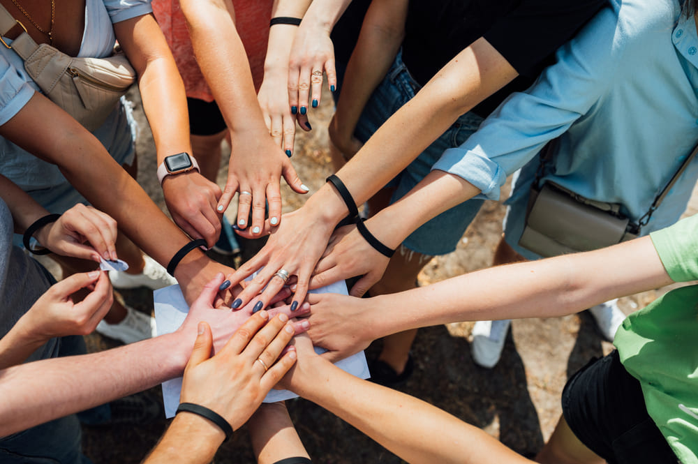 A group of people joining hands after breaking the ice
