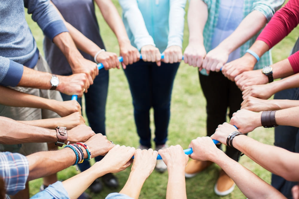 A group holding a hoop together during an ice-breaking activity