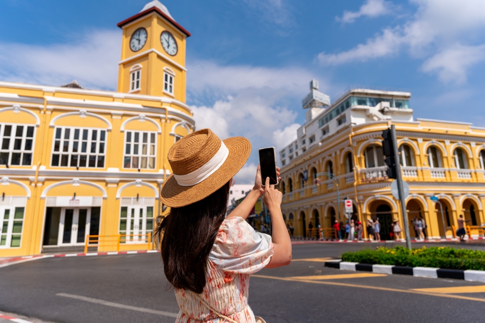 woman walking and taking a photo at Phuket old town in Thailand