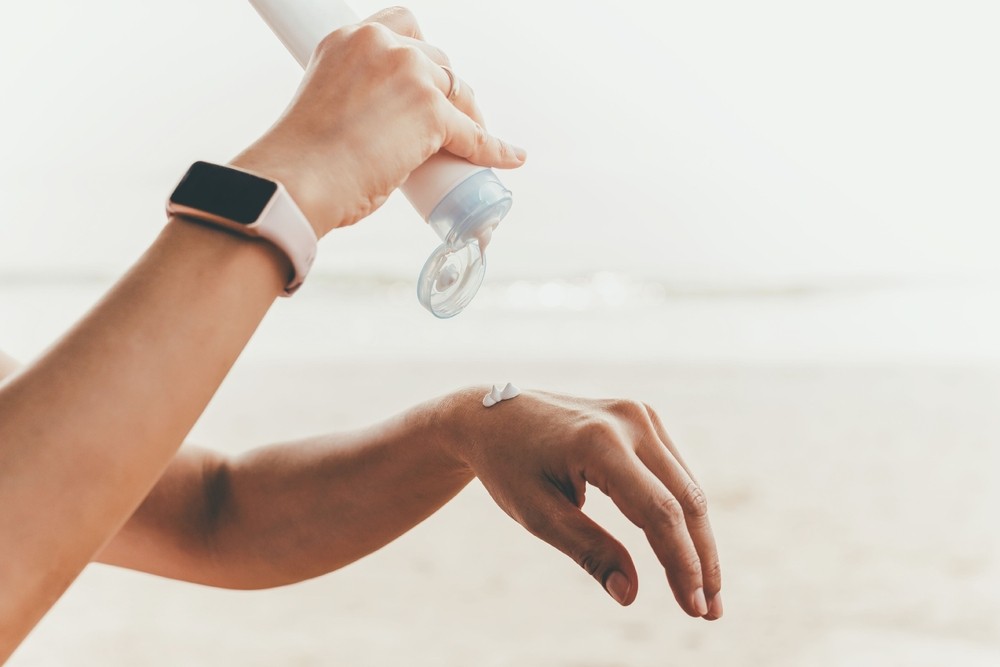 woman squeezes sunscreen on her hand before applying